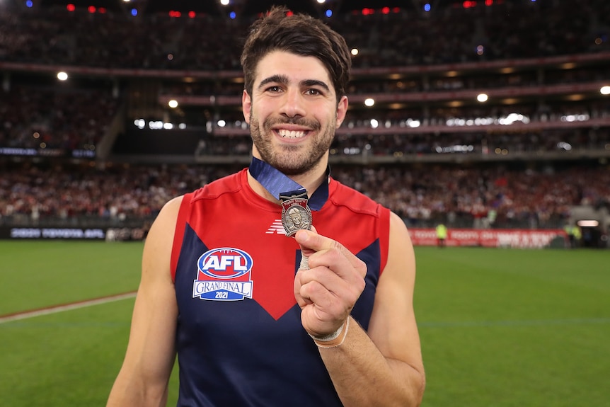 A Melbourne AFL player poses with the Norm Smith Medal.