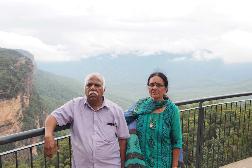 Srihari's parents at a scenic lookout, overlooking mountains and bush