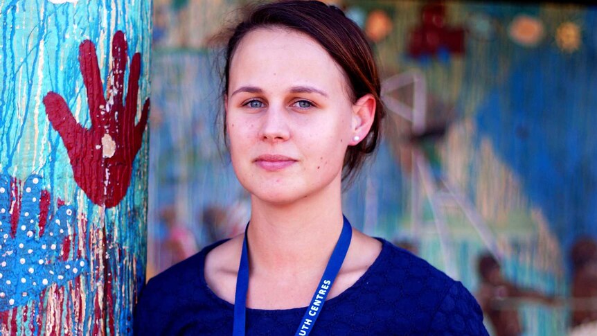 Roebourne PCYC manager Samantha Cornthwaite standing next to a brightly painted pole, wearing a blue top and lanyard.