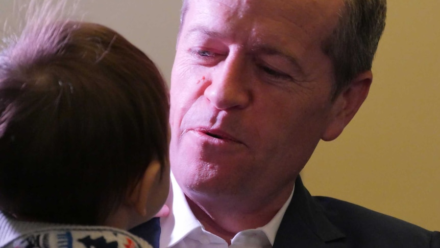 Opposition Leader Bill Shorten holds a baby at a Melbourne childcare centre.