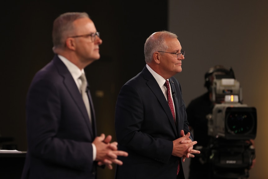 Albanese and Morrison pull the same pose, listening with each of their fingers entwined