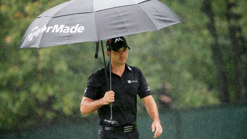 Jason Day walks with umbrella at Tour Championship