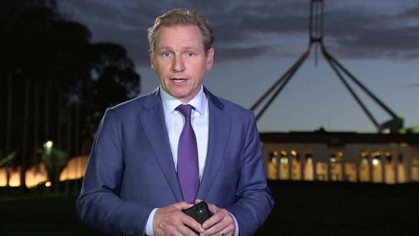 Probyn standing in front of Parliament House in Canberra at dusk.