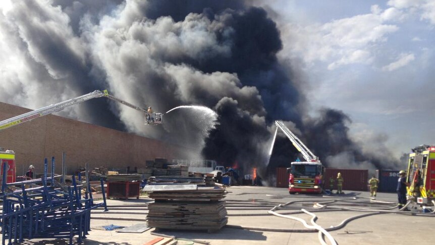 Firefighters battle a large blaze at a factory fire in Sydney's south-west