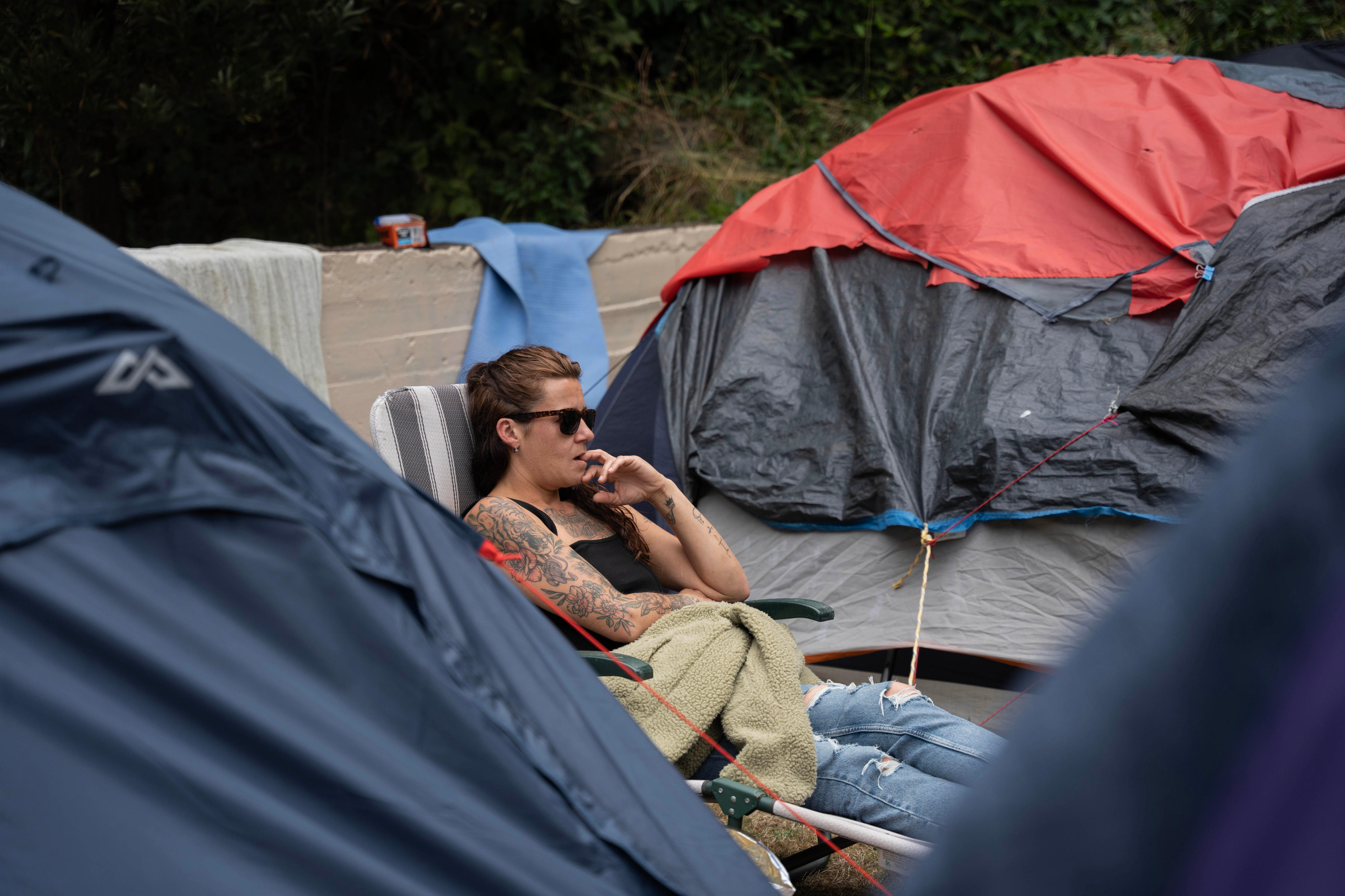 女人坐在被帐篷包围的椅子上。 