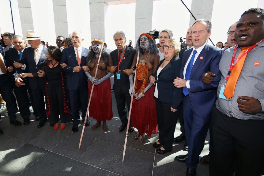 Politicians and indigenous leaders link arms for the No More anti-domestic violence campaign at Parliament House in Canberra.