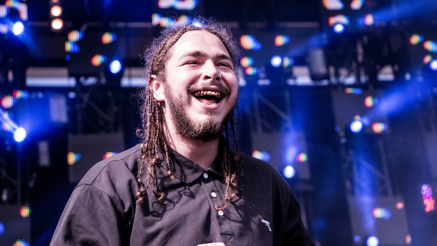 Post Malone smiling on a stage