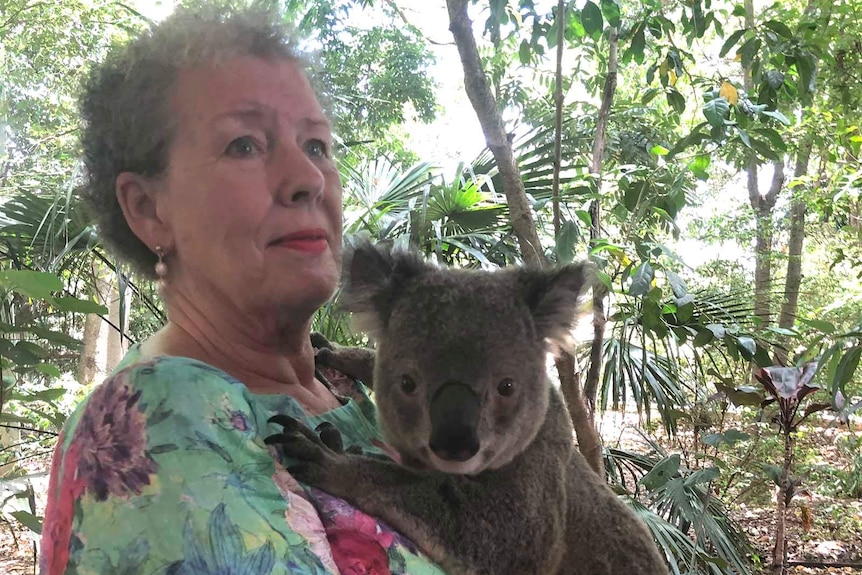 A woman holding a koala