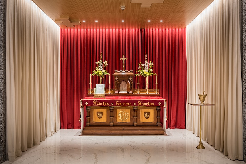 A curtained room with altar decorated by religious accoutrements.