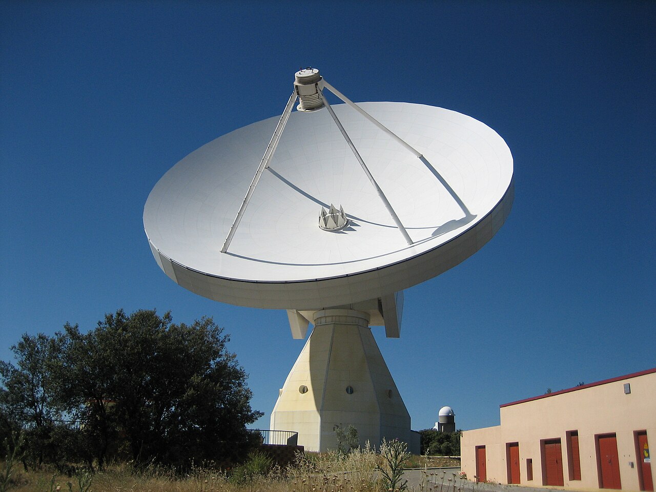 A large telescope dish pointing to the sky during the day.