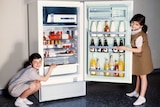 Two children next to a fridge in a 1960s ad