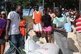 A Haitian man pushes a wheelbarrow of aid supplies