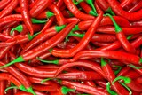 A pile of red chillis at the shops, bright green stems are an indicator of freshness.