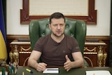 Ukrainian president in brown t-shirt speaks during nationwide address from office.