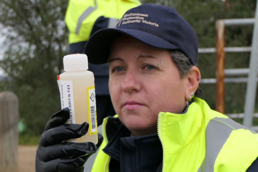 Inspector Sara Durey holds a small beaker with water in it