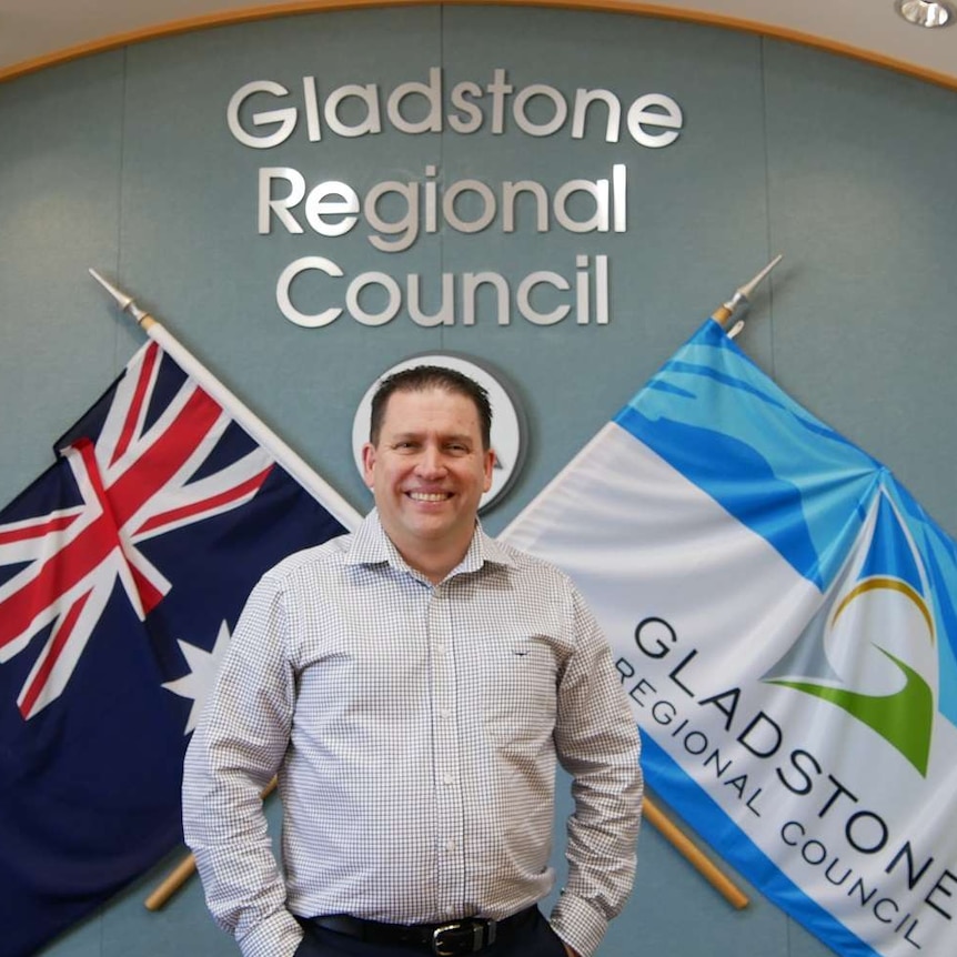 A man with short dark hair stands in front of a Gladstone Regional Council sign.