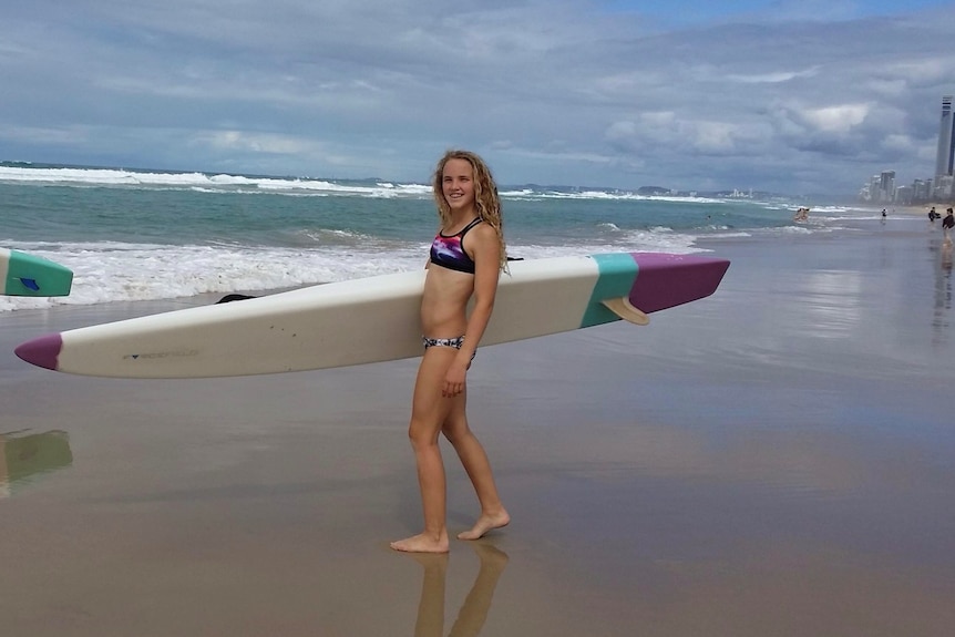 Teenage girl walks along the beach near the waves ... she is just 14 when photo was taken