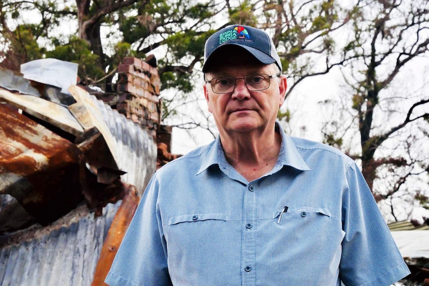 A man wearing a blue shirt looks towards the camera.