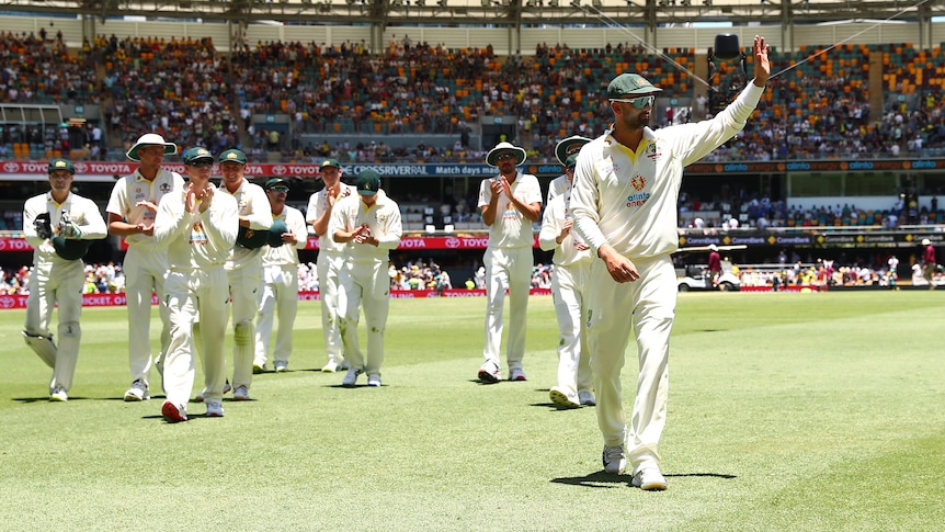 Nathan Lyon leads the Australian team off the field as he waves to the crowd