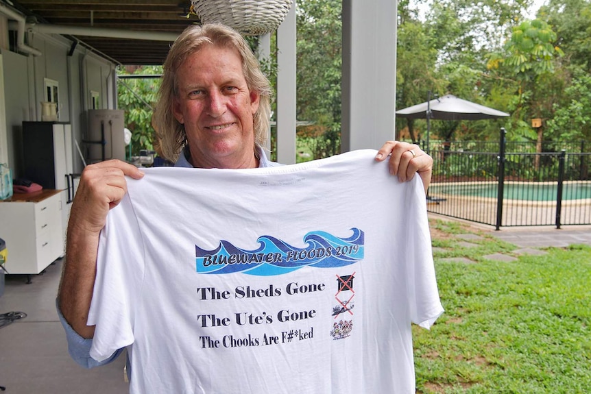 Bluewater resident Roger Goodwin holds up a t-shirt that commemorates the 2019 Townsville floods.