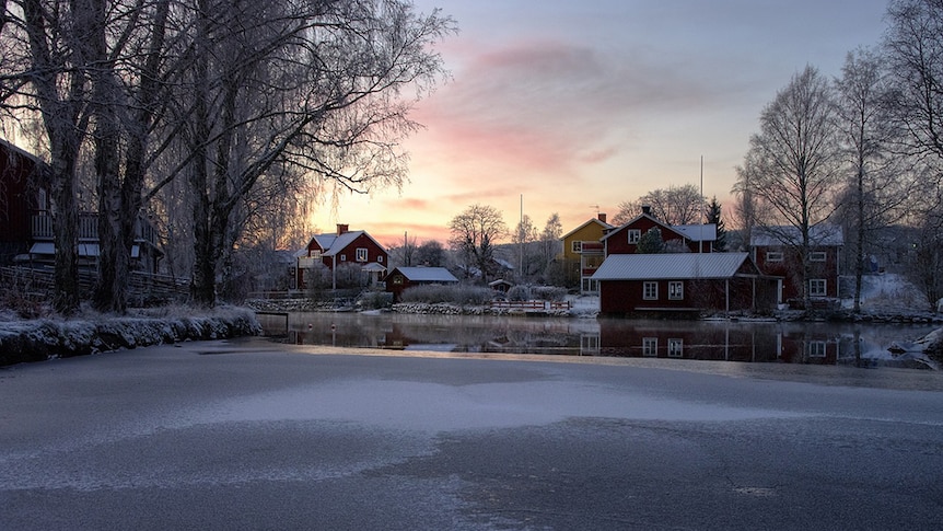 Snow covered landscape along a frozen river in Sundborn Sweden.