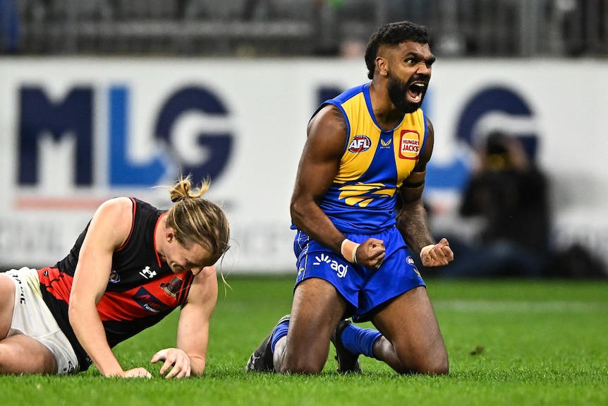 On his knees, Liam Ryan screams in delight. Mason Redman looks sad next to him