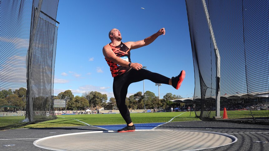 Matthew Denny throws a discus in competition