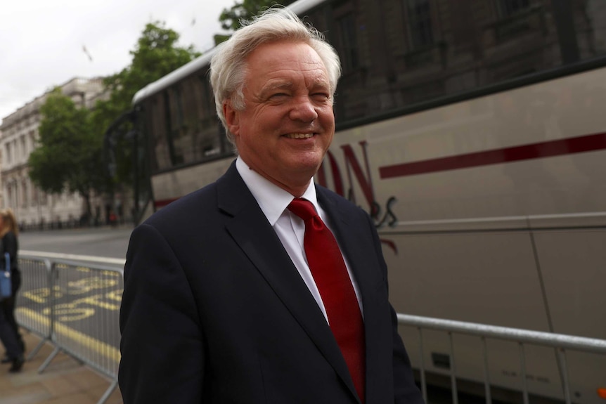 David Davis smiles as he walks out of the Cabinet office in Westminster.