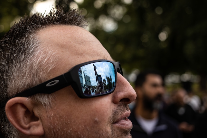 A reflection of Warne’s statue in the sunglasses of Kane Walker of Melbourne.
