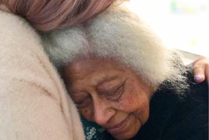 A younger woman holding an older woman