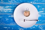 a can of tuna sits on a plate. 