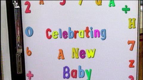 Magnetic letters on a fridge spell out 'Celebrating a new baby'