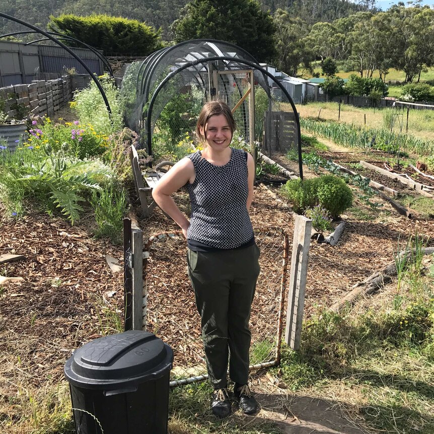 Elicia Casey-Winter standing in her very impressive permaculture garden, surrounded by growing veggies.
