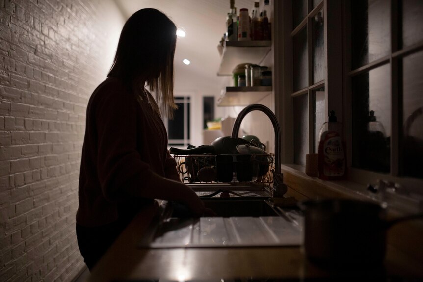 Close up of unidentifiable woman in kitchen.
