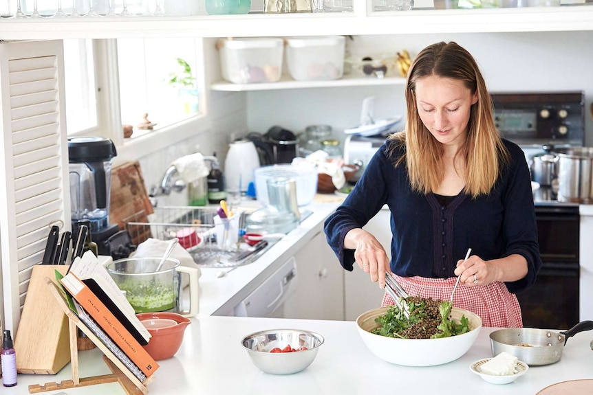 Dietician Heidi Sze in her kitchen and tossing lentils and greens in a salad bowl.