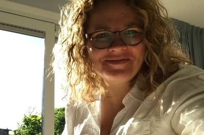 Woman in glasses sitting at a desk.