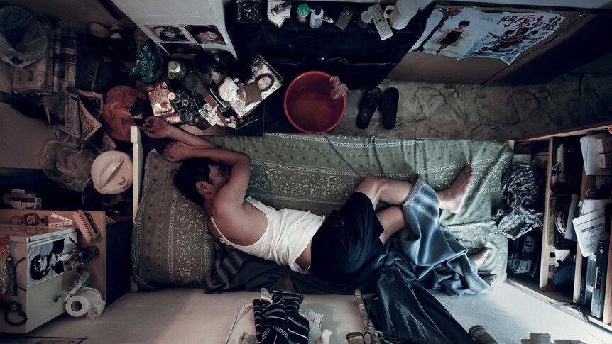 A man sleeps in tiny flat in Hong Kong.