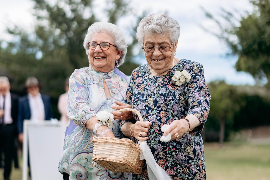 Grandmothers spread flowers at a wedding.