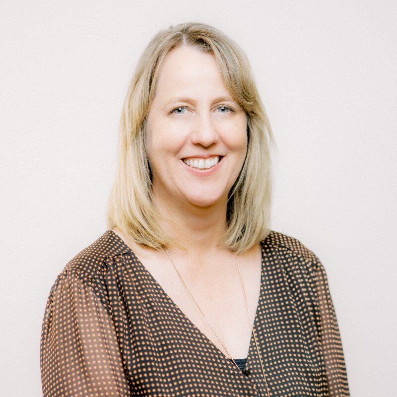 Una mujer con cabello largo y rubio, sonriendo.
