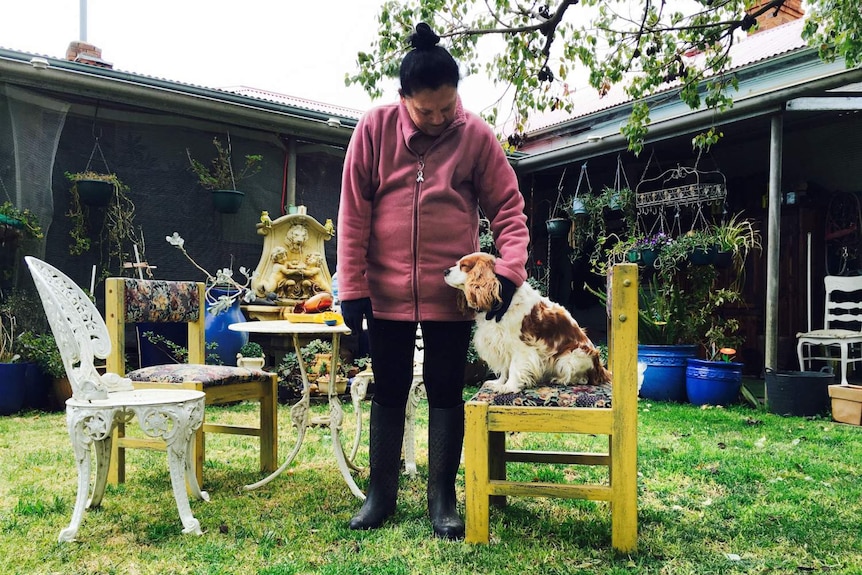 A woman pats her dog.