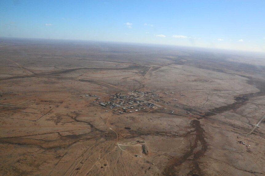 Wide aerial shot of a small town in the middle of the outback.