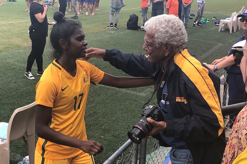 Le jeune joueur de Matildas Shay Evans embrasse l'ancien champion de football Socceroo et autochtone John Moriarty