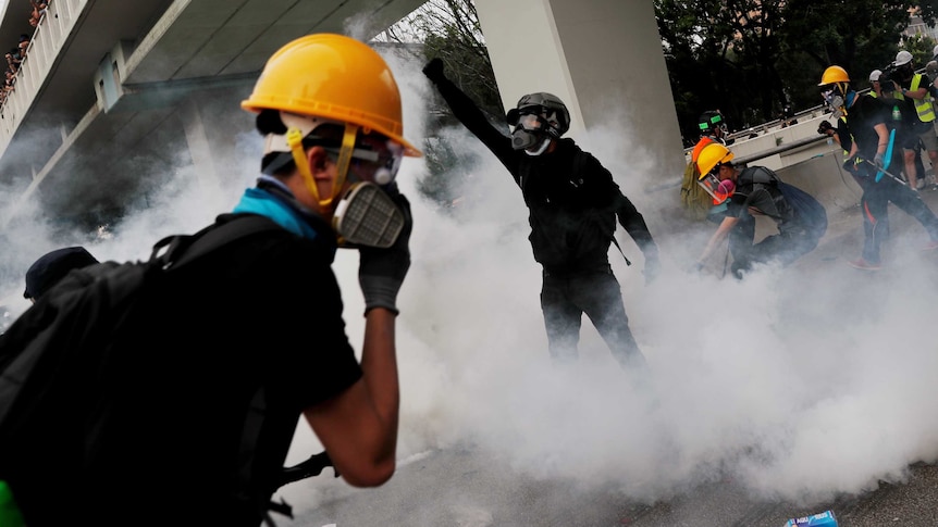 demonstrators react to tear gas