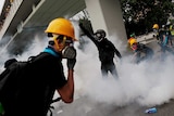 demonstrators react to tear gas