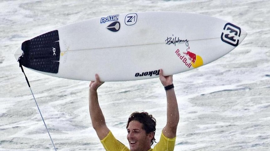 Andy Irons raises his board after scoring a 9.87 wave