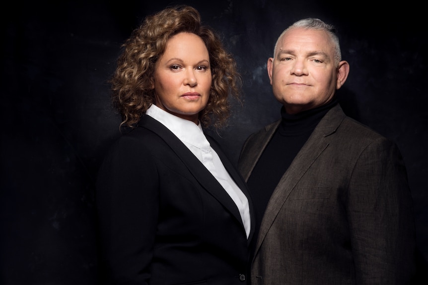 An Indigenous man and an Indigenous woman dressed formally looking at the camera