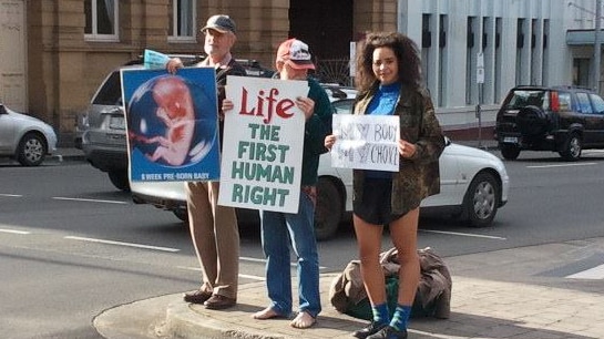 A pro-choice protester joins an anti-abortion demonstration.