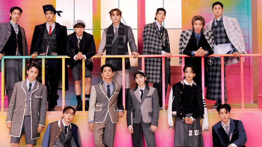The members of Seventeen pose for a photo wearing preppy outfits. 