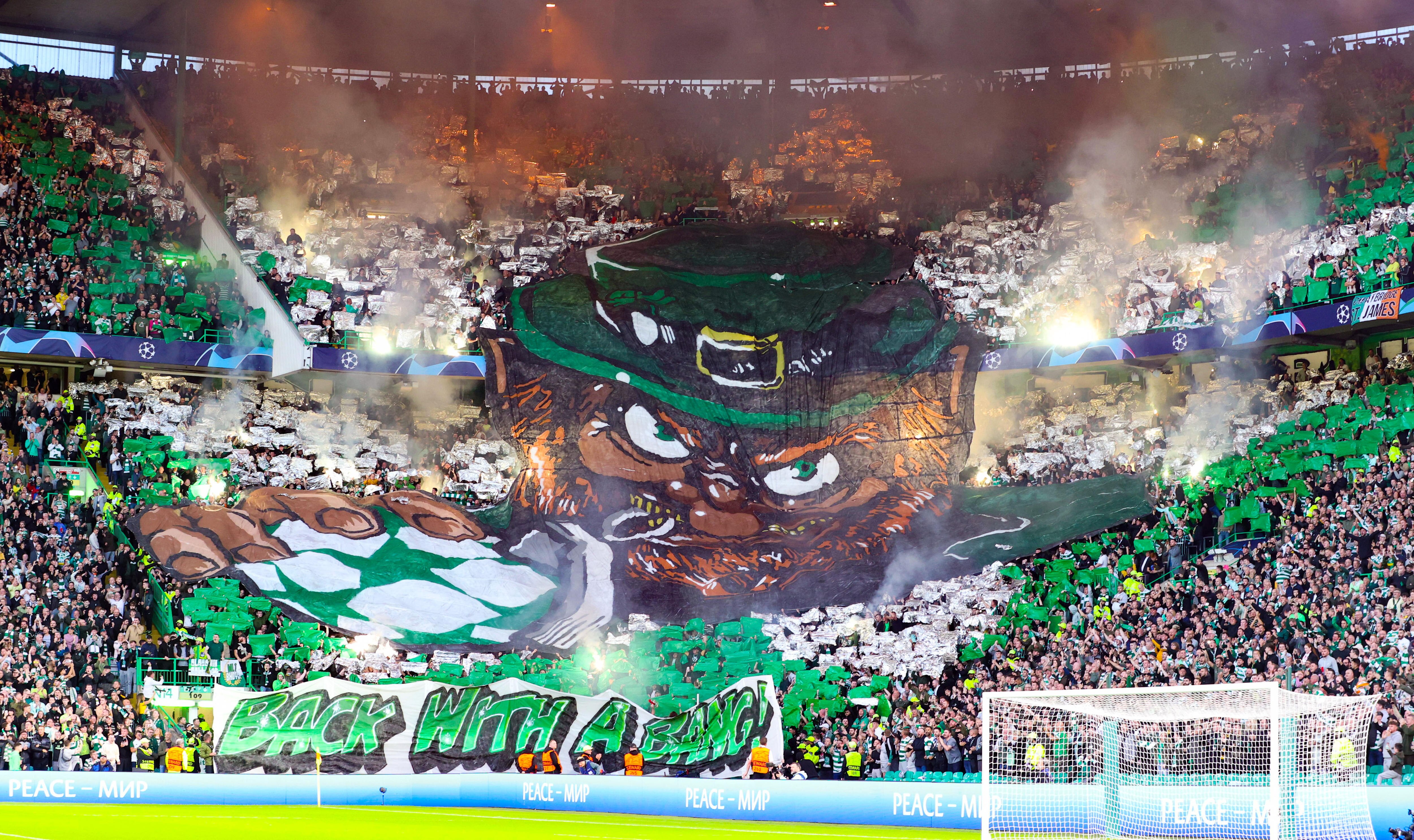 Celtic fans make a giant display of an angry leprechaun with a soccer ball and the sign 'Back with a bang'.
