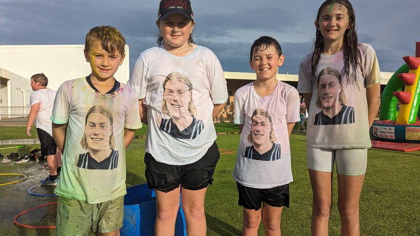 Four kids all wearing white shirts with the face of football player Harley Reid 